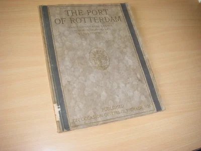 Tweedehands boek: The Port of Rotterdam van auteur Dekking, H.; J. Wytema (Burgomaster, preface) - Ingenaaide Engelstalige tekst van 93 pagina's, waarin al talloze prachtige z-w foto's van stad, haven en bedrijven zijn afgedrukt, dit alles omgeven door nog eens 64 pagina's met advertenties van bij de haven betrokken bedrijven, waarin ook foto's van plek en bedrijvigheid te bewonderen zijn, aangevuld met een uitgebreide index van waar welke bedrijven in de tekst te vinden zijn. Van buiten bezien een gewoon werkje, maar eenmaal opengeslagen met een schat aan gegevens over de situatie tegen de dertiger jaren van de vorige eeuw. Af en toe staat er een stempeltje in van de Bibliotheek openbare werken. 
The continental centre of world-shipping and world commerce was published on occasion of the Olympiade 1928
