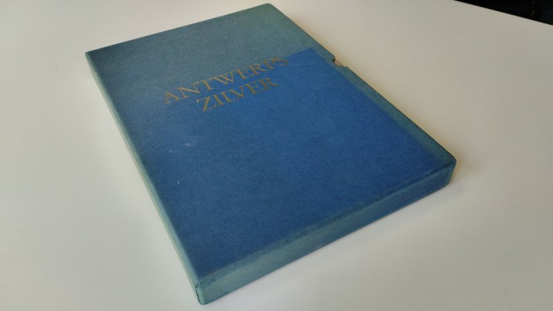 Tweedehands boek: Antwerps Zilver van auteur Baudouin, Piet & Anne-Marie Claessens-Pere & Paul Huvenne & Iris Kockelbergh - Blauwe cassette met 2 softcover boeken. De cassette is verkleur, de boek hebben kleine gebruikerssporen aan de kaft. Pagina's netjes en onbeschreven. In goede staat.