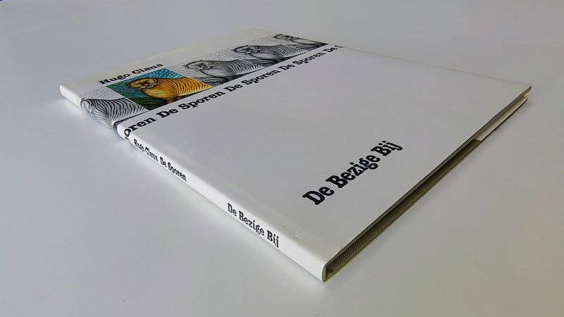 Tweedehands boek: De sporen van auteur Hugo Claus - Hardcover met stofomslag. Omslag licht verkleurd, geen gebruikerssporen. Witte bladzijdes lichte verkleuring langs de randen, verder onbeschreven en netjes.