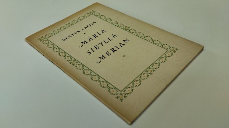 Tweedehands boek: Maria Sibylla Merian van auteur Bertus Aafjes - In goede staat. Geniete softcover met flappen. Lichte ouderdomsverkleuring aan kaft en rug. Pagina’s schoon en stevig. Nederlandstalige uitgave. Ouderdoms vlekjes binnenkant kaft