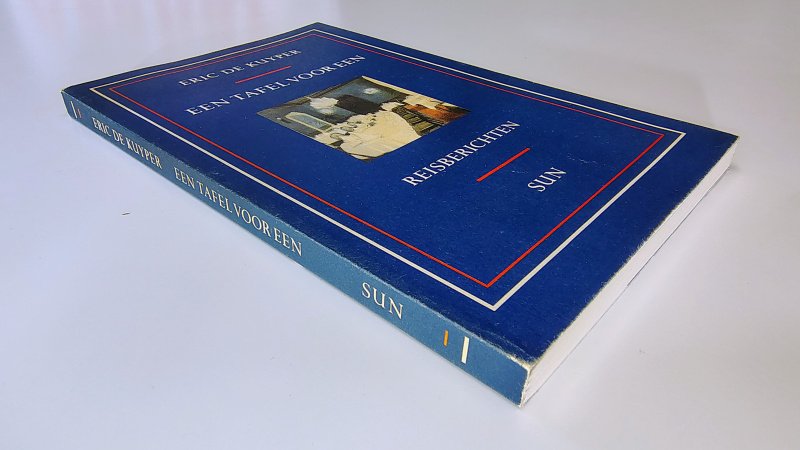 Tweedehands boek: Een tafel voor een Reisberichten van auteur Eric de Kuyper - Paperback met flappen, lichte slijtage langs de randen kaft en rug. Rug is recht zonder leesvouwen en licht verkleurd. Ex-libris reliëf stempel voorin, verder onbeschreven en netjes.