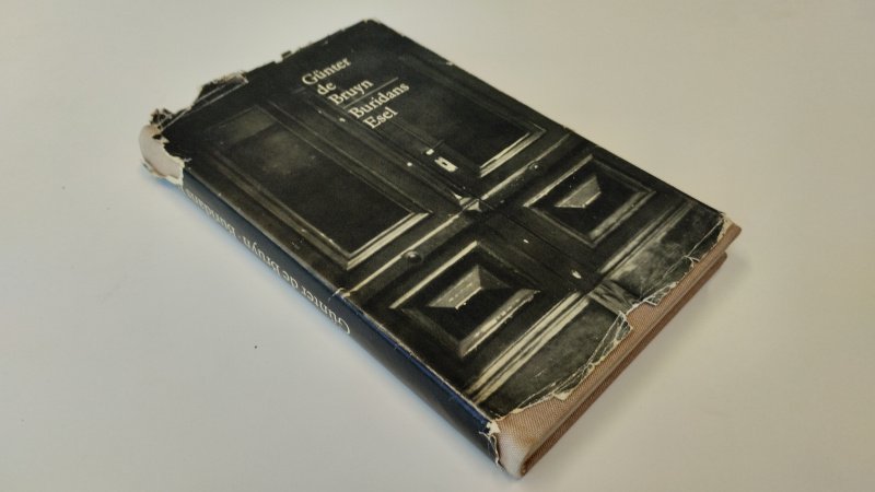 Tweedehands boek: Buridans Esel van auteur Gunter de Bruyn - In redelijke tot goede staat. Duitstalige hardcover met stofomslag. Stofomslag beschadigd en geschaafd aan randen en hoeken. Rug en band stevig. Pagina’s verder netjes leesbaar. Op schutblad een stempel en er is geschreven.