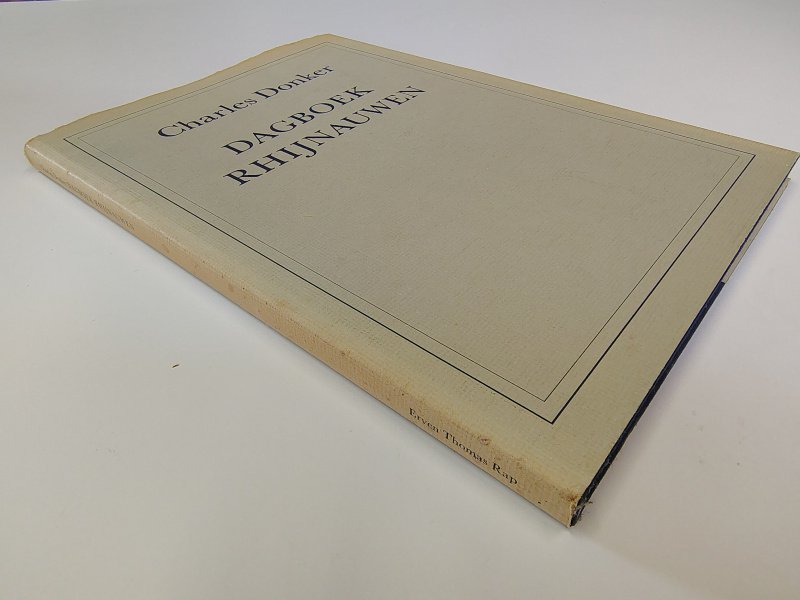 Tweedehands boek: Dagboek Rhijnauwen van auteur Charles Donker - Hardcover met stofomslag. Omslag langs de randen en rug verkleurd en versleten. Linnen blauwe kaft met zilveropdruk netjes. Ex-libris stempeltje voorin, verder onbeschreven en netjes. Roestvlekjes bovenzijde snede.