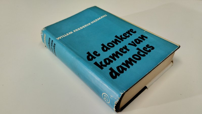 Tweedehands boek: De donkere kamer van Damokles van auteur Willem Fredrik Hermans - In redelijke staat. Nederlandstalige hardcover met stofomslag (welke duidelijk slijtagesporen vertoont). Ex Libris reliefstempel voorin. Pagina's verkleurd, maar netjes, onbeschreven en stevig in de binding (iets scheve rug