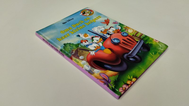 Tweedehands boek: Oma Duck en haar kleine helpers van auteur Walt Disney - In goede staat. Nederlandstalige hardcover. Lichte gebruikssporen aan de kaft. pagina's netjes, onbeschreven en stevig in de binding