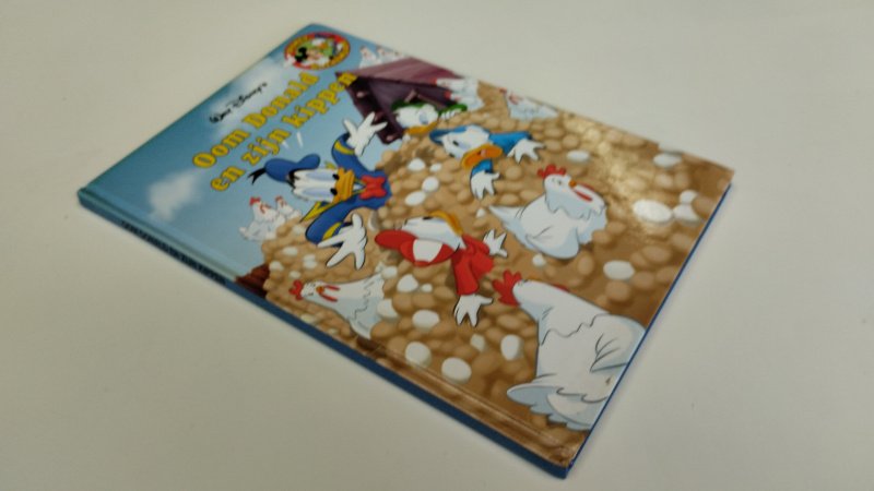 Tweedehands boek: Oom Donald en zijn kippen van auteur Walt Disney - In goede tot zeer goede staat. Nederlandstalige hardcover met lichte gebruikssporen aan de kaft. Pagina's netjes, onbeschreven en stevig in de binding