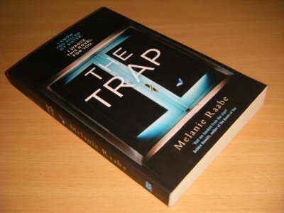 Tweedehands boek: The Trap van auteur Melanie Raabe - Paperback, crease in spine, in good condition.
